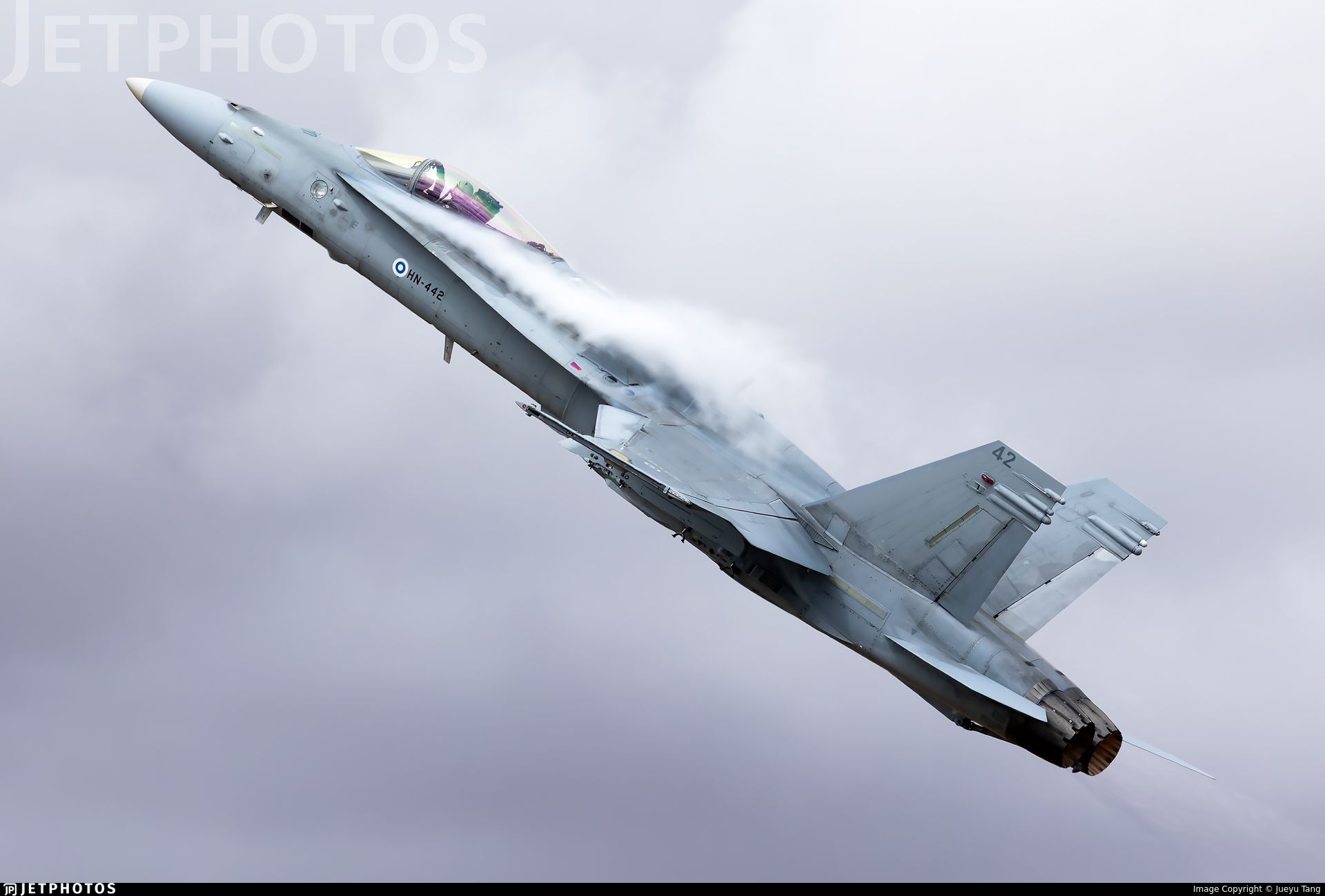 Finnish Air Force F/A‑18 Hornet climbing steeply with vapor trailing from its wings