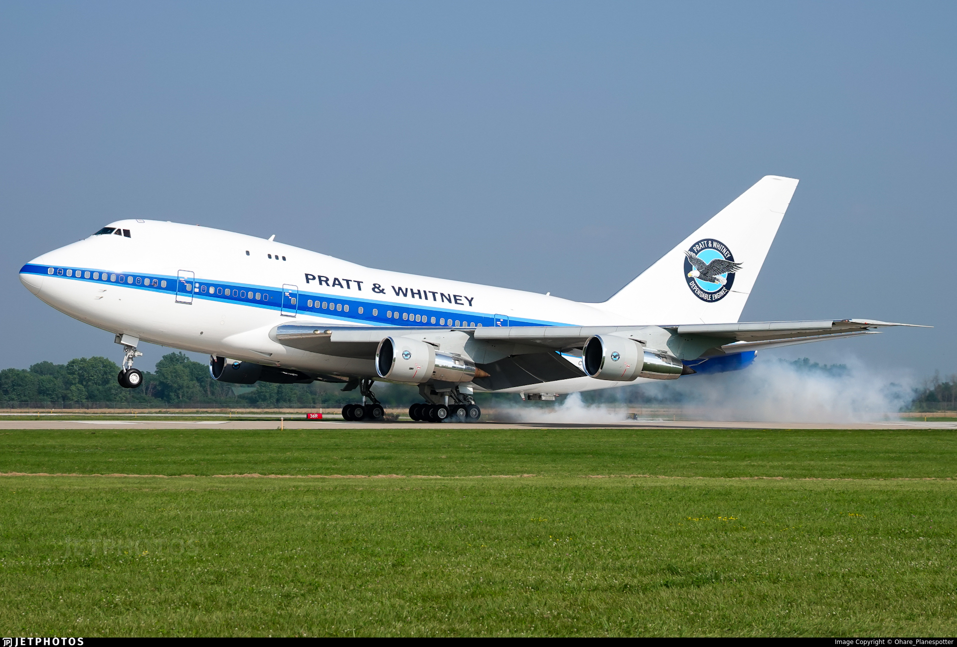 Pratt & Whitney Boeing 747 testbed aircraft taking off with smoke trailing from the landing gear